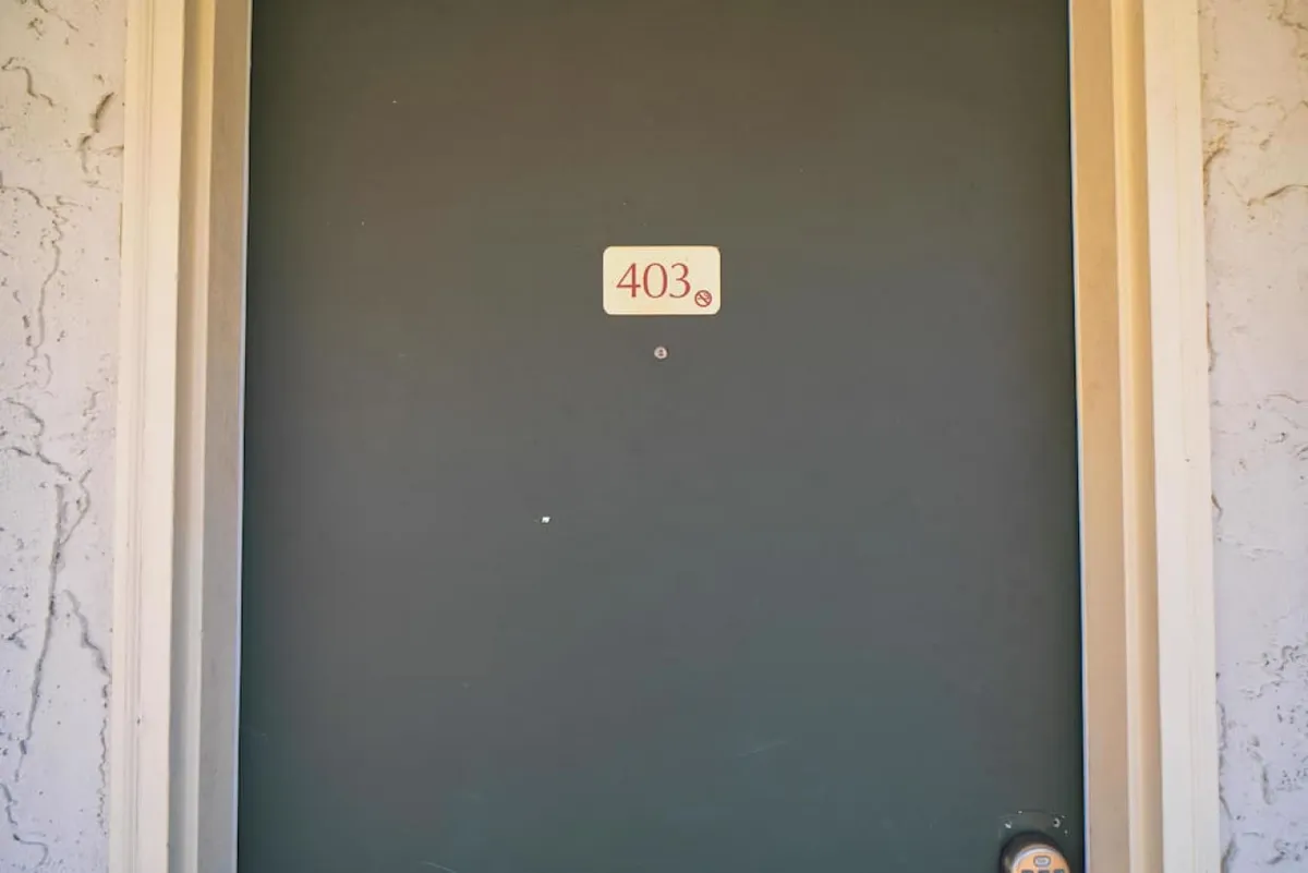 The front door of the unit, marked with '403,' stands slightly ajar, inviting guests to enter. The image captures the anticipation of arrival and the ease of entry.